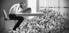 Overworked exhausted businessman writes with a typewriter